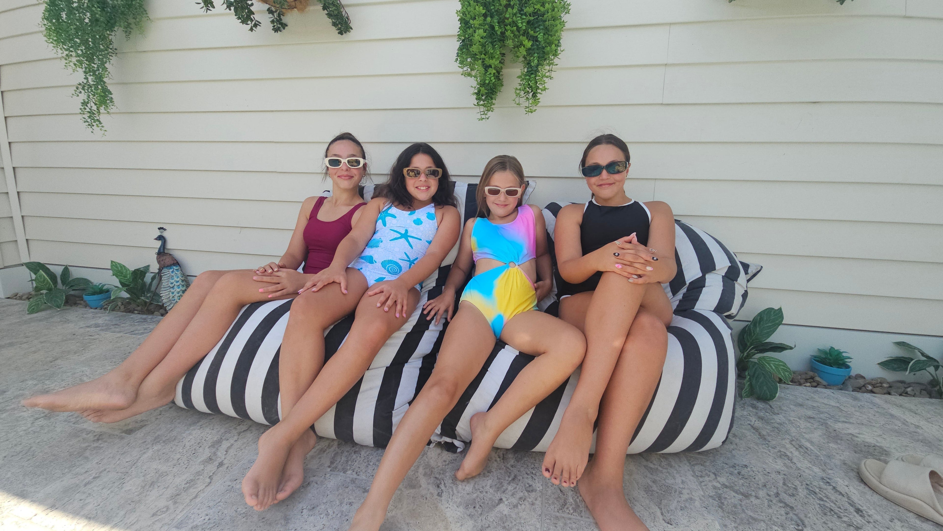 Tween and teen girls wearing age-appropriate one-piece swimwear