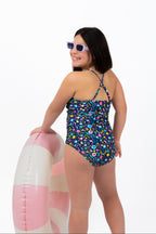 Back flat lay view of the Coastal Bloom floral one-piece swimsuit showing adjustable cross-back straps and full coverage fit.