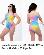 Front and back view of girl wearing the Cotton Candy Cut-Out rainbow one-piece swimsuit with centre ring detail, side cut-outs, and full coverage fit while holding a beach ball.