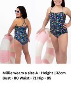 Front and back view of girl wearing the Coastal Bloom floral one-piece swimsuit with side ruching detail, adjustable cross-back straps, and full coverage fit.