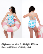 Front and back view of girl wearing the Seafoam Sweetie one-piece swimsuit with seashell and starfish print, adjustable tie-back straps, and full coverage fit.